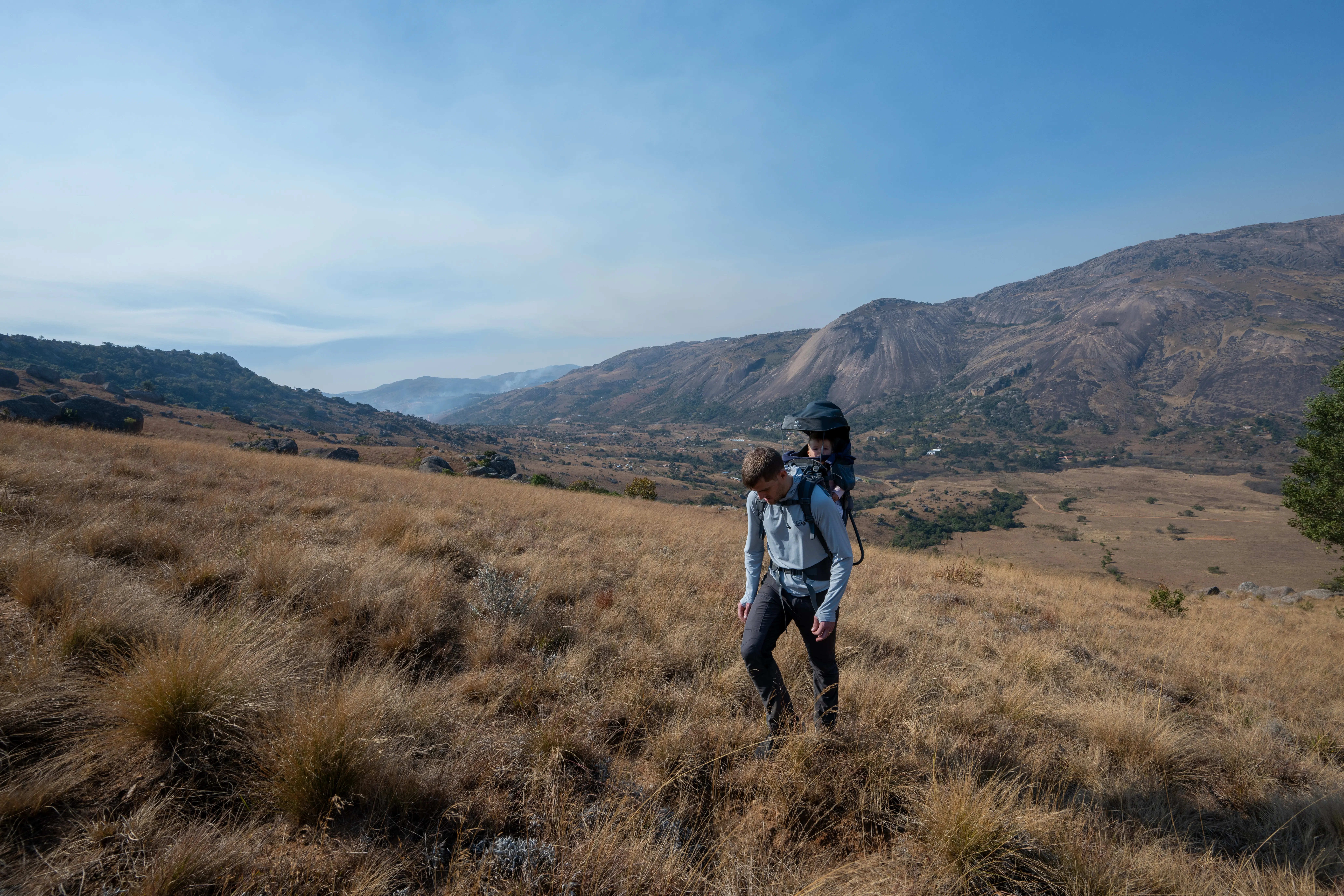 Sonja hiking up the mountain in her new backpack carrier, with our airbnb far below. Sibebe is in the background, on the opposite side of the valley.
